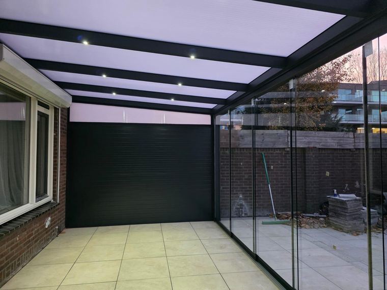 Veranda met glazen schuifwanden en verlichting in het dak